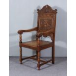 An Oak Armchair of "17th Century Wainscot" Design, with shaped and carved crest rail, carved back