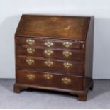 A George III Oak Bureau, the slope enclosing pigeon holes and six small drawers, four long drawers