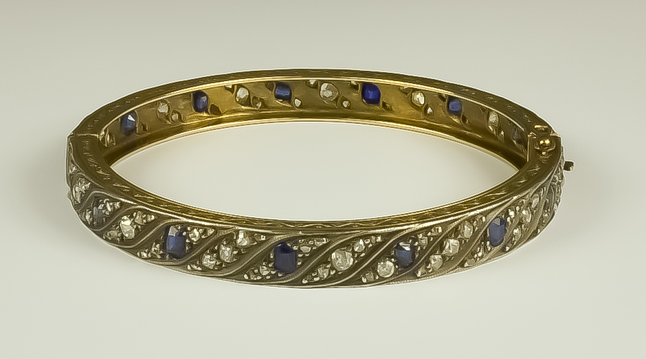 A Gilt Metal Bracelet, Early 20th Century, set with fourteen faceted sapphires and approximately