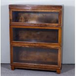 A Globe Wernicke Oak Three-Tier Sectional Bookcase, with glazed rising fronts, on block feet,