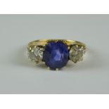 A Sapphire and Diamond Three Stone Ring, 20th Century, 18ct gold set with a centre sapphire,