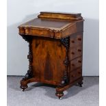 A Victorian Figured Walnut Davenport, with lidded superstructure, leather lined slope enclosing four