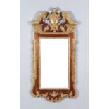 A Grained Wood and Gilt Decorated Wall Mirror of "Mid 18th Century" Design, of shaped outline,