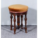 A Victorian Walnut Circular Adjustable Piano Stool by James Shoolbred & Co, the seat upholstered