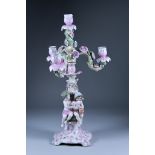A Continental Porcelain Four-Branch Candelabrum, the lower part modelled with two children, the