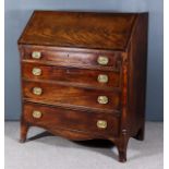 A George III Mahogany Bureau, the slope enclosing pigeon holes, central cupboard and four small
