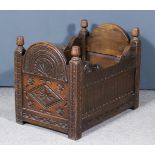 A 20th Century Panelled Oak Log Box/Crib of "17th Century" Design, with shaped ends carved with