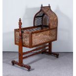 An Early Victorian Mahogany Framed and Caned Panelled Baby's Crib, with turned uprights and finials,