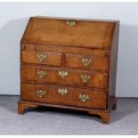 A George III Oak Bureau, the slope enclosing stepped interior, fitted four small drawers and