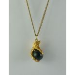 A 9ct Gold Pendant, Modern, in the form of a talon clutching a ball, suspended from fine 9ct gold