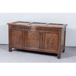 A 17th Century Panelled Oak Coffer, with three-panel lid and front with moulded rails and fluted