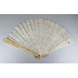 I* A Chinese "Cantonese" Ivory Fan, 19th Century, the end sticks carved with figures in a garden,