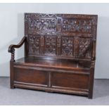 A Late Victorian Panelled and Carved "Black Oak" Hall Settle, the high back with six panels carved