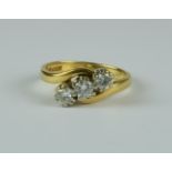 A Diamond Three Stone Crossover Ring, Modern, set with approximately .50ct brilliant cut round