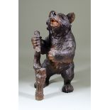 A Black Forest Linden Wood Tobacco Jar, 19th Century, carved as a standing bear clutching a staff in