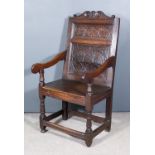 A 17th Century and Later Oak "Wainscot" Armchair, the panelled back with scroll carved cresting,