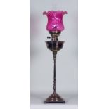 A Victorian Plated Oil Lamp with Plain Reservoir, on square slender turned central column and square