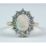 A Opal and Diamond Ring, Modern, 18ct yellow gold set with a central opal, 8mm x 10mm, surrounded by