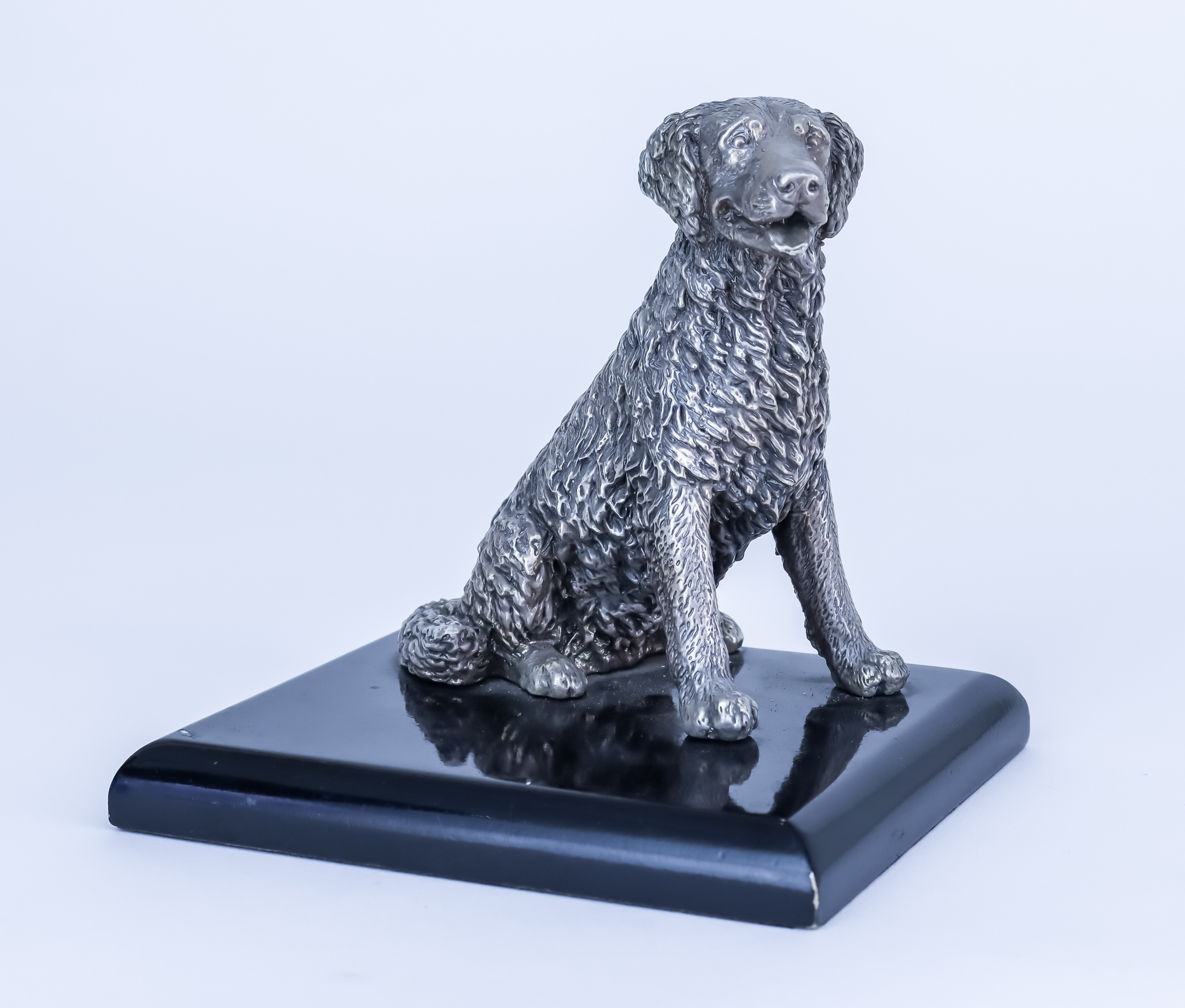A 20th Century Cast Silvery Metal Model of a Seated Retriever, on rectangular ebonised base, 5ins