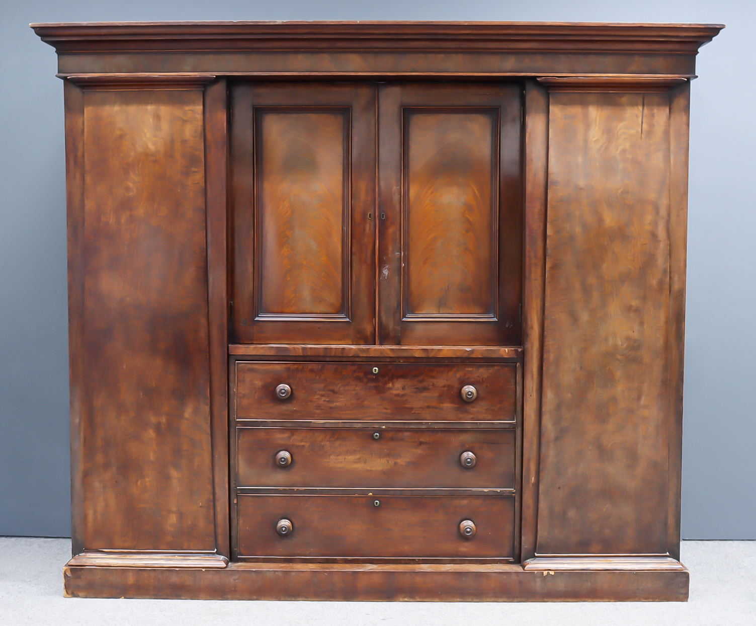 A Victorian Figured Mahogany Breakfront Wardrobe, with moulded cornice, fitted central recessed