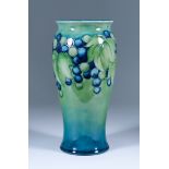 A Moorcroft Pottery Baluster Shaped Vase, decorated in greens and blues with leaf and berry pattern,