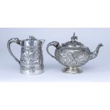 A Near Eastern Silvery Metal Bulbous Teapot and Similar Hot Water Pot, each embossed and chased with