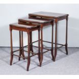 A Nest of Three Edwardian Mahogany Rectangular Occasional Tables, the tops inlaid with satinwood