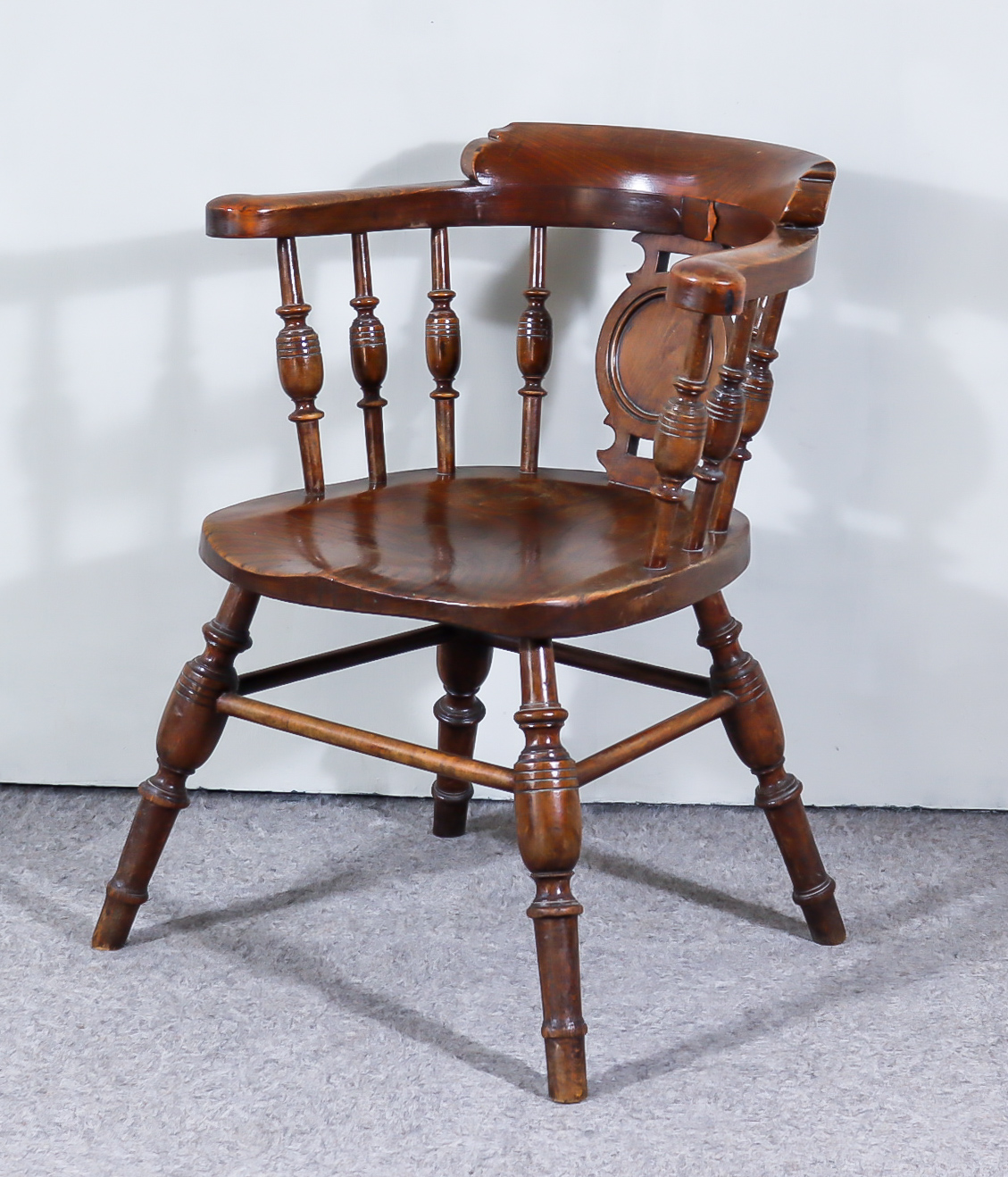 A Victorian Elm Smoker's Bow Armchair, with curved crest rail, central shaped splat, spindle