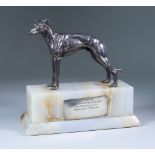 A Silvered Metal Model of Standing Greyhound, 5.75ins high, mounted on white flecked onyx