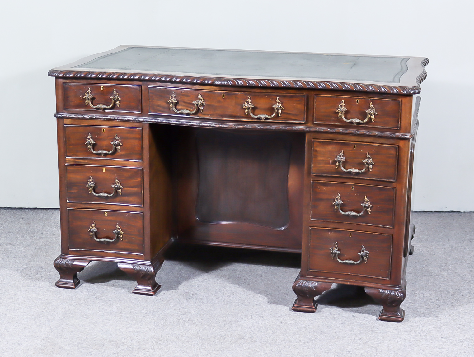 An Early 20th Century Mahogany Kneehole Desk of "Georgian" Design, of serpentine outline, inset with