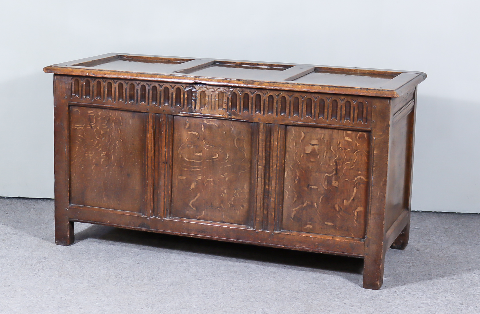 A 17th Century Panelled Oak Coffer, with three-panel lid and front with moulded rails and fluted