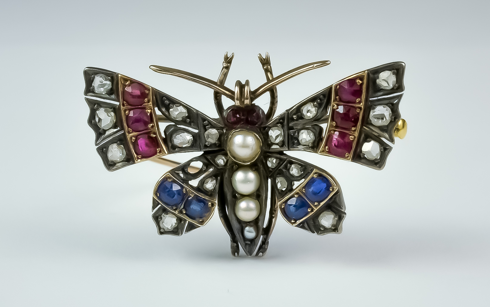 A Diamond, Sapphire and Ruby Brooch, Late 19th/ Early 20th Century, yellow and silver metal set with