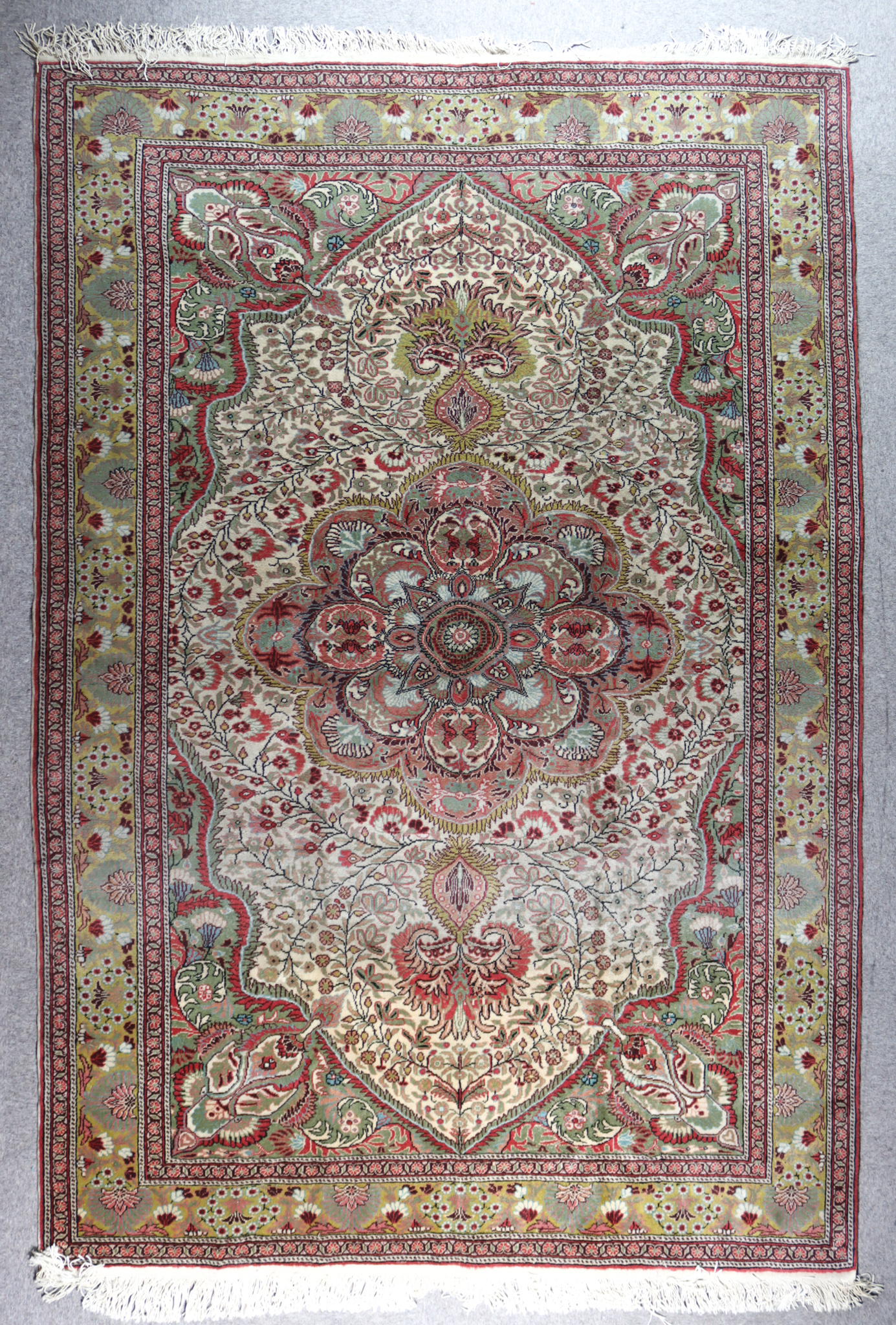 An Early 20th Century Kayseri Carpet, woven in muted colours with a bold central flower head