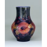 A Moorcroft Vase, tubelined with "Pomegranate" design, on a blue ground, 8.5ins high, impressed