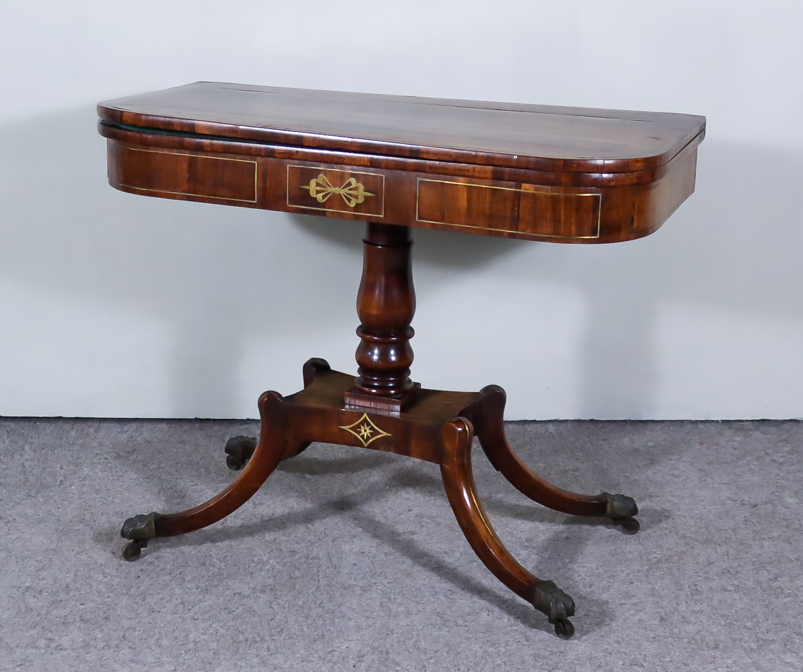 A George IV Rosewood D Shaped Card Table, inlaid with brass stringings, the green baize lined