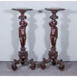 A Pair of 19th Century Continental Stained and Walnut Torcheres, the tops with shaped, moulded and