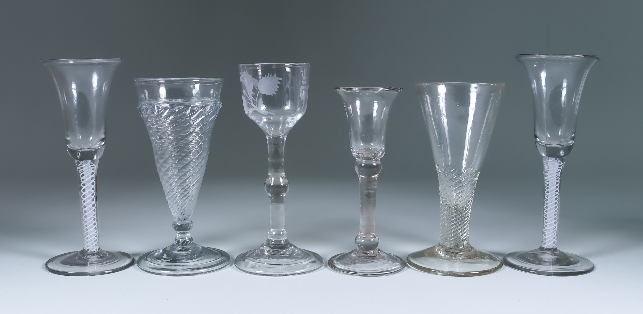 Six Drinking Glasses, 18th Century, including - a pair of wine glasses with bell bowls, plain cotton