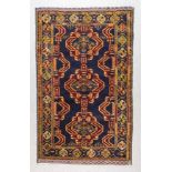 A Late 20th Century Rug of Persian Design, woven in colours of navy blue, wine and green, with three