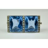 A Blue Topaz and Diamond Brooch, Early 20th Century, white metal set with two large faceted blue