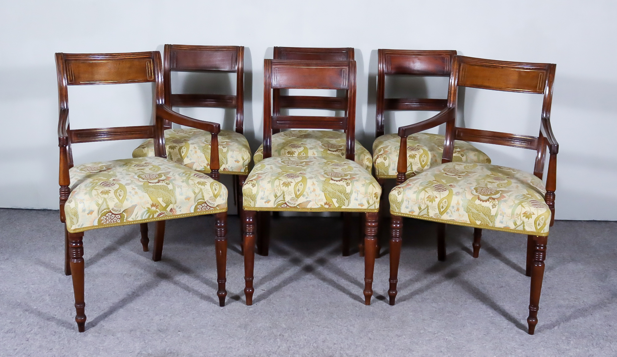 A Set of Six Late George III Mahogany Dining Chairs, (including two armchairs), the crest rails with