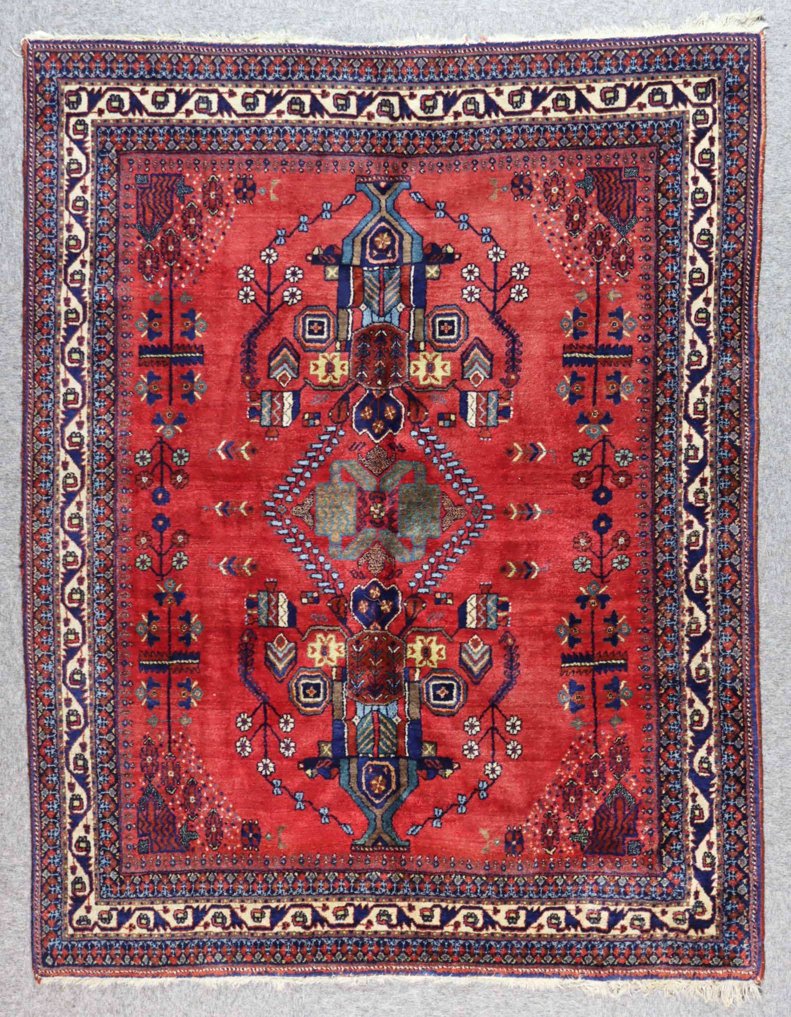 An Early 20th Century Afshar Rug, woven in colours of ivory, navy blue and wine, with central flower