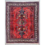 An Early 20th Century Afshar Rug, woven in colours of ivory, navy blue and wine, with central flower