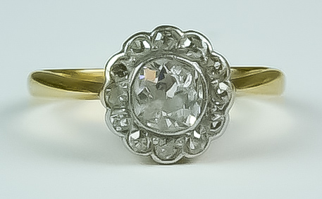 A Diamond Flower Head Ring, 20th Century, 18ct gold set with a centre diamond. approximately .