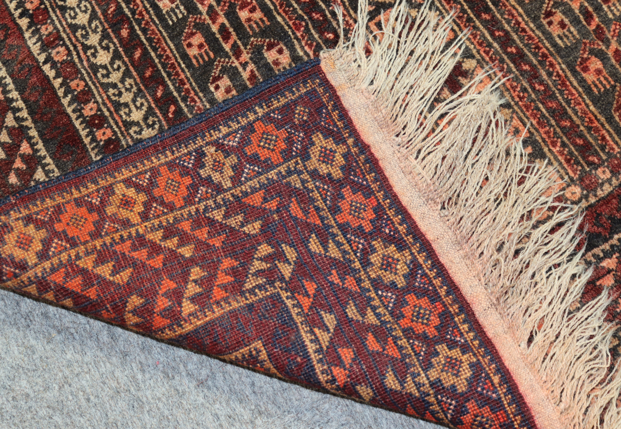 A Mid-20th Century Turkmen Enzi Rug, woven in navy blue, wine and fawn, with panels of hooked motifs - Image 3 of 3