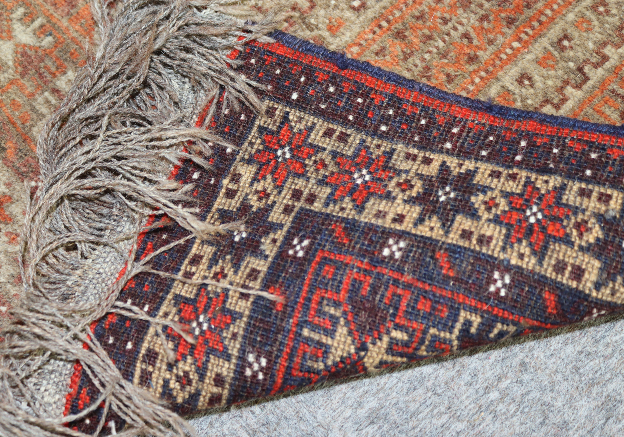 A Mid-20th Century Turkmen Enzi Rug, woven in navy blue, wine and fawn, with panels of hooked motifs - Image 2 of 3