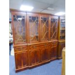 A LARGE MODERN YEWWOOD BREAKFRONT LIBRARY BOOKCASE, HAVING 4 GLAZED DOORS TO UPPER SECTION, THE BASE