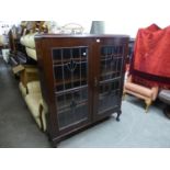 A DARK MAHOGANY DWARF BOOKCASE ENCLOSED BY TWO LEADED AND STAINED GLASS DOORS, ON STUMP CABRIOLE