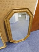 AN OCTAGONAL BEVELLED EDGE WALL MIRROR IN GILT FRAME