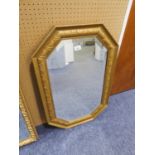 AN OCTAGONAL BEVELLED EDGE WALL MIRROR IN GILT FRAME