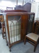 A MAHOGANY DISPLAY CABINET WITH LEDGE BACK, SERPENTINE FRONT, CENTRE PANEL FLANKED BY ASTRAGAL